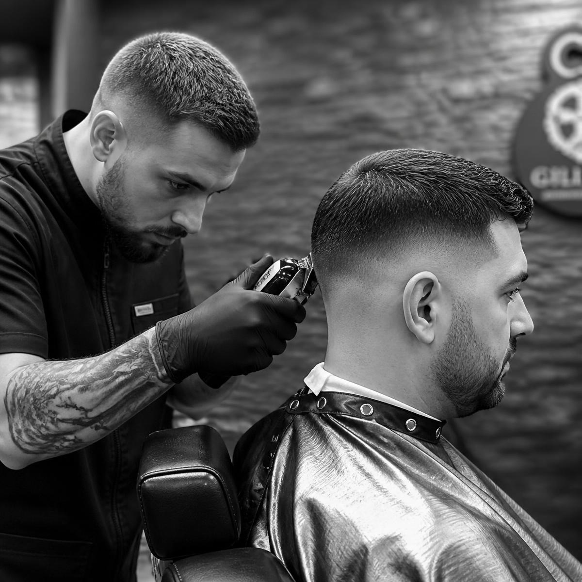 Barber cutting a precision fade with chrome clippers
